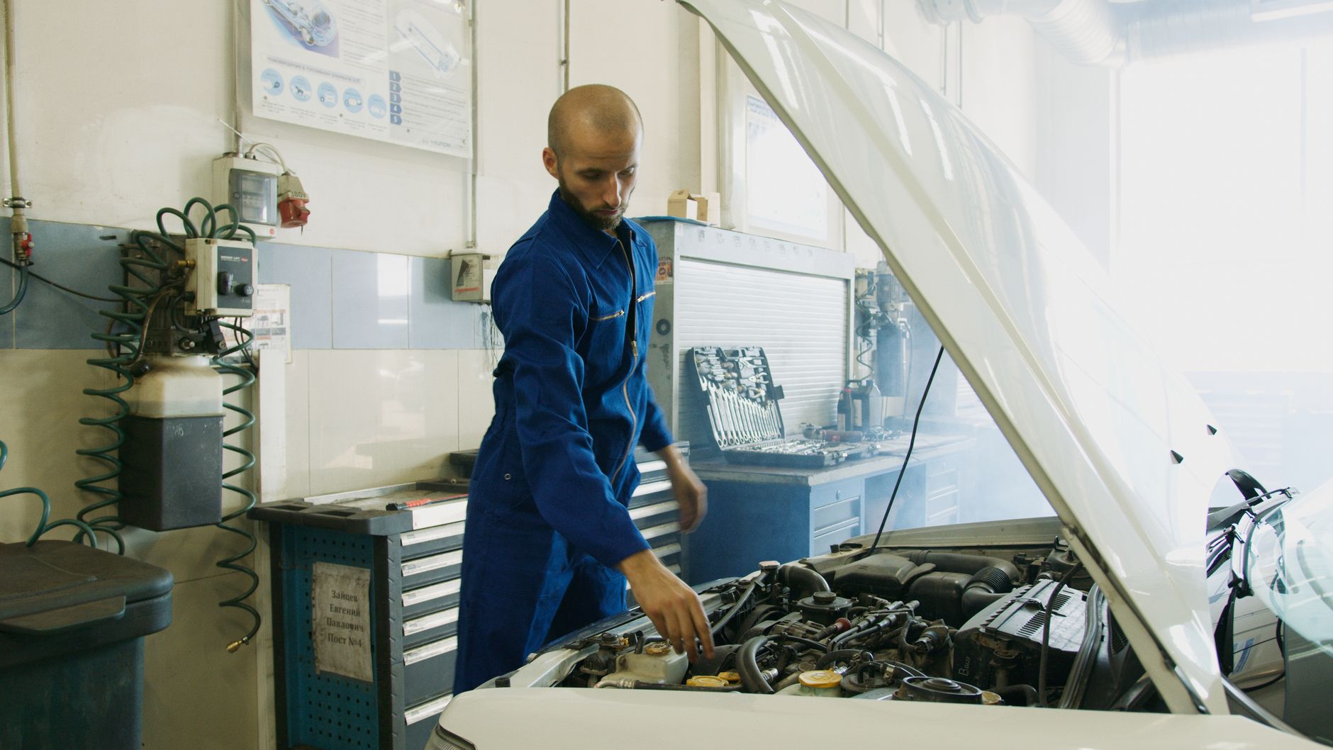 Importer aut z Czech na co uważać przy pierwszym serwisie i wymianie podzespołów Mechanik w niebieskim kombinezonie sprawdza silnik auta w warsztacie