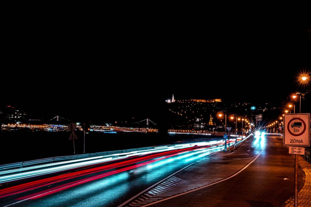 Nocny ruch samochodowy na ulicy w Budapeszcie z miejską panoramą